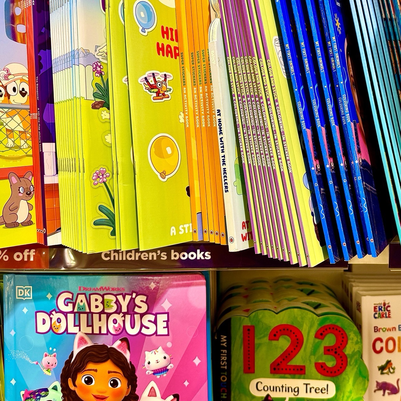 Brightly illustrated children’s books fill a shop shelf, including picture books and early counting titles.