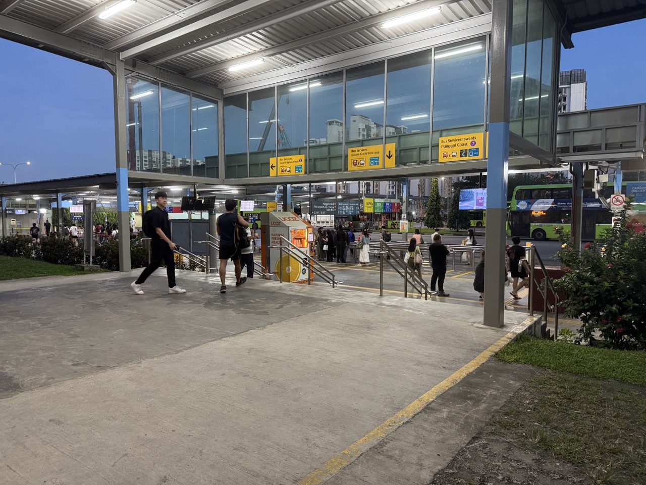 People at Punggol bus interchange during sunset.