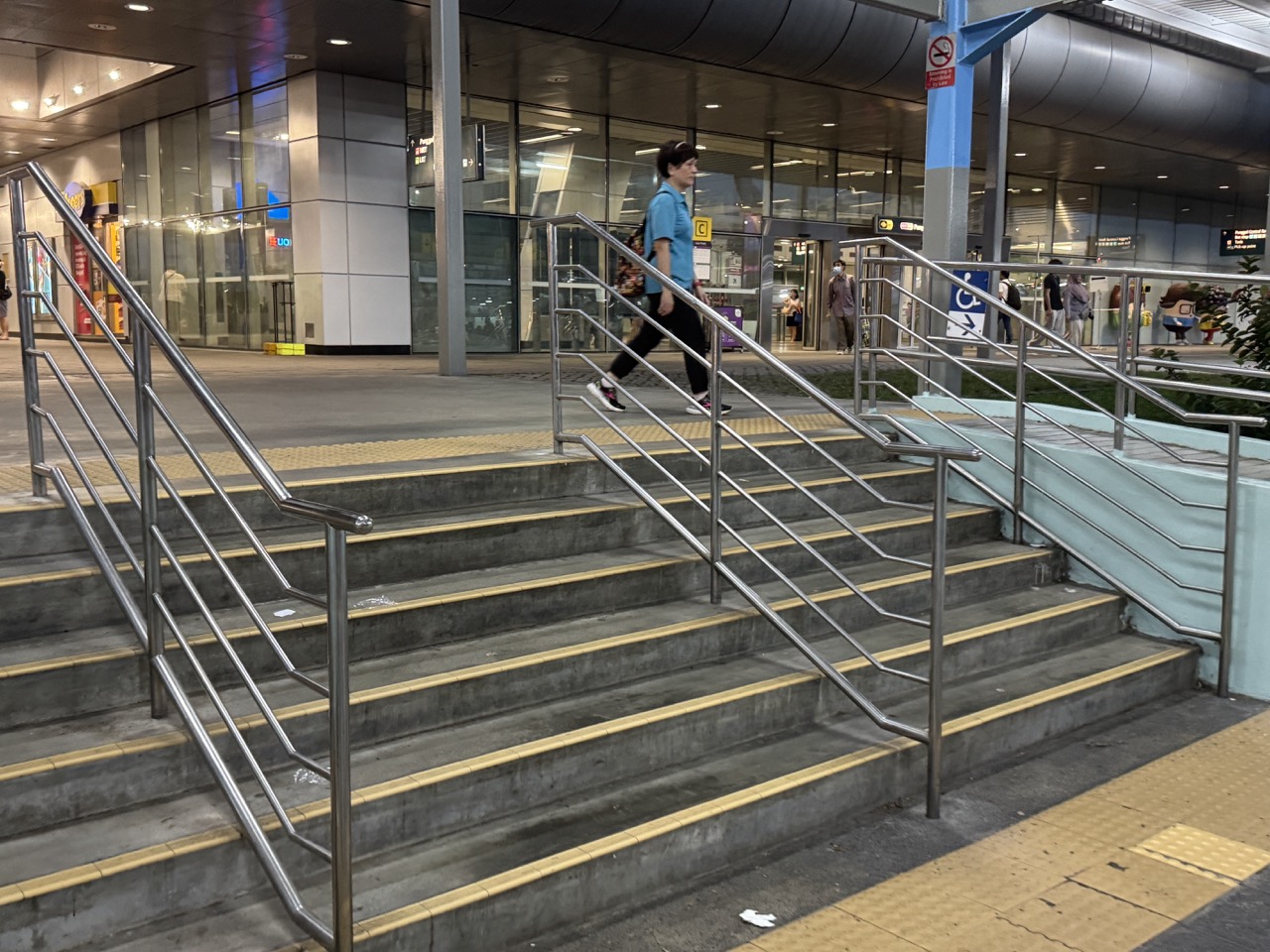 Stairs at a Punggol MRT station exit leading toward the bus interchange.