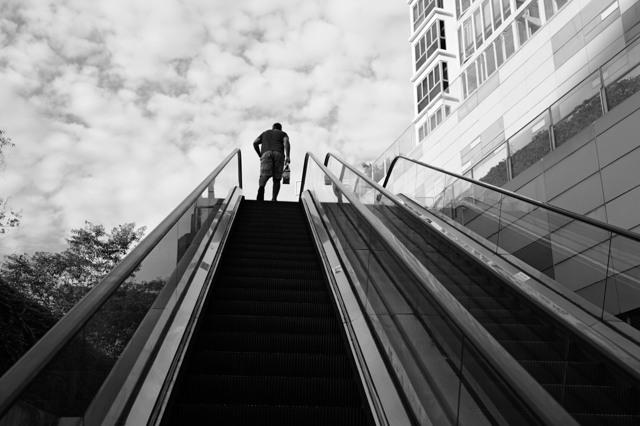 Outdoor escalator between Waterway Point and Watertown with a delivery worker silhouetted at the top