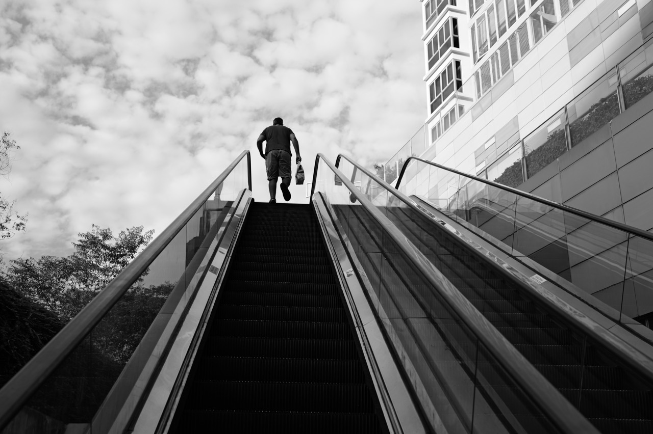 Outdoor escalator between Waterway Point and Watertown with a person silhouetted at the top