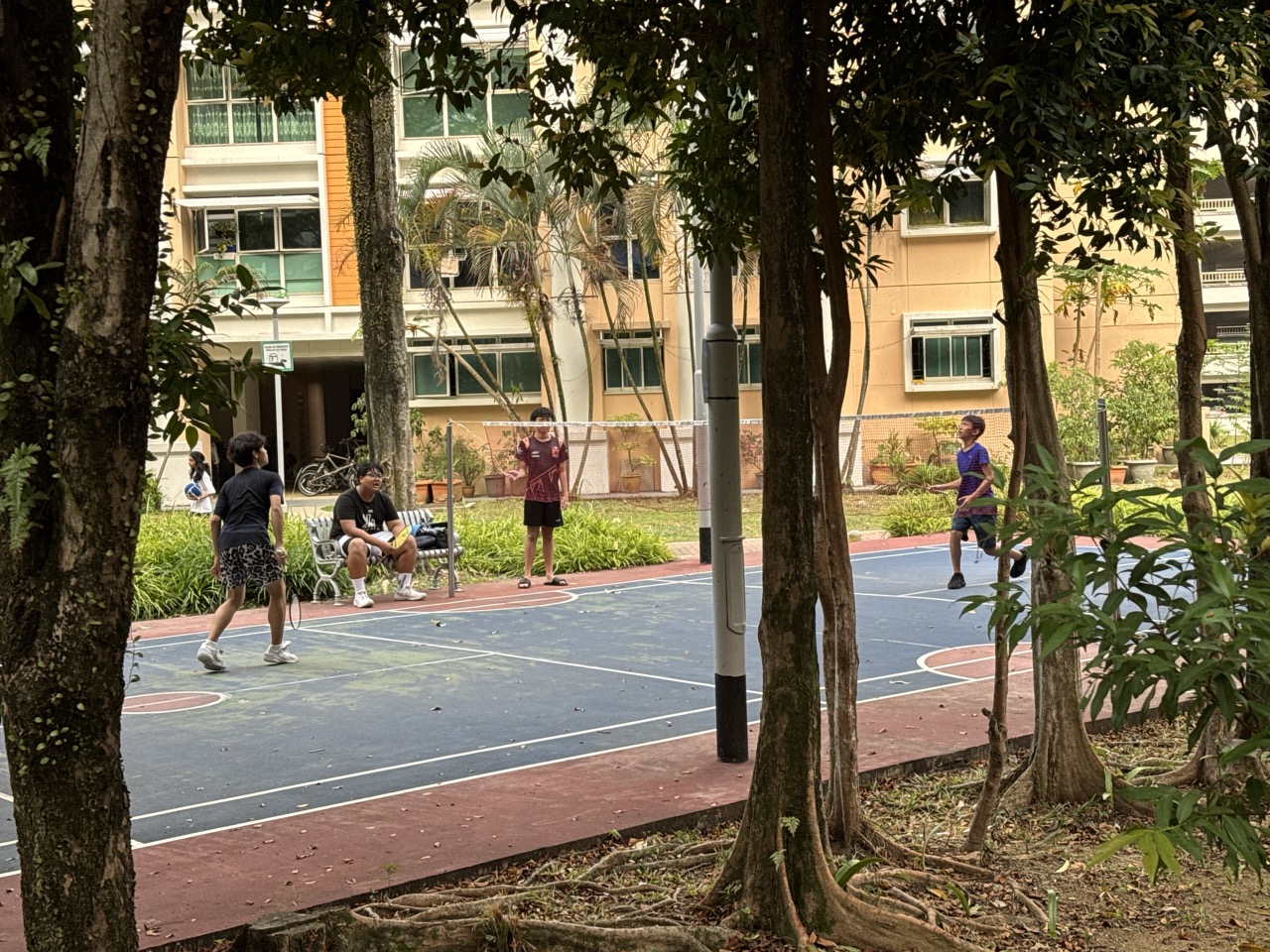 People playing badminton on an outdoor court near Playground 295 in Punggol.