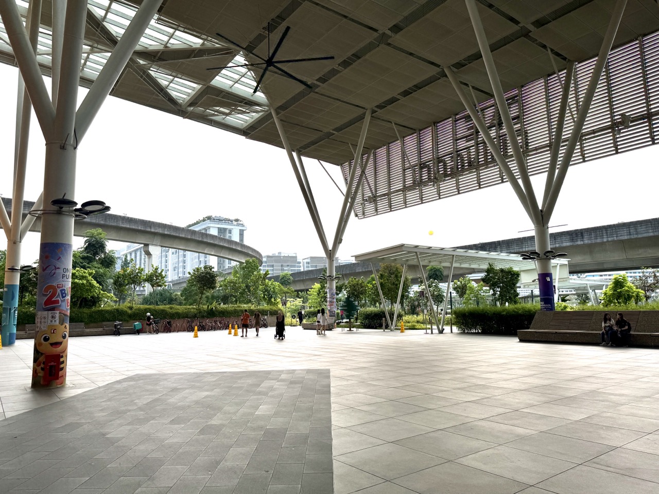 Open space at One Punggol with elevated LRT tracks behind the community hub.