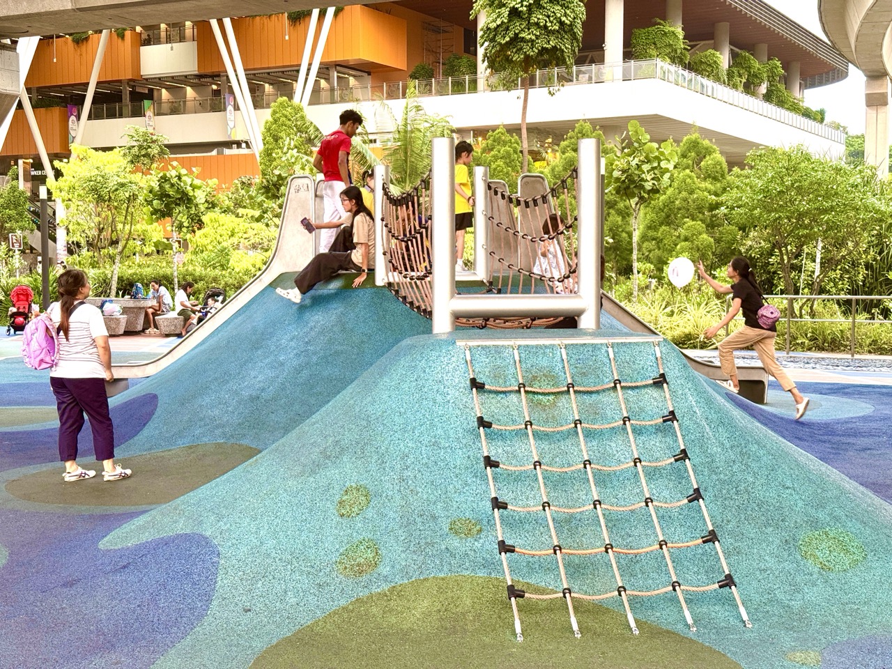Families at a playground below elevated LRT tracks in Punggol.