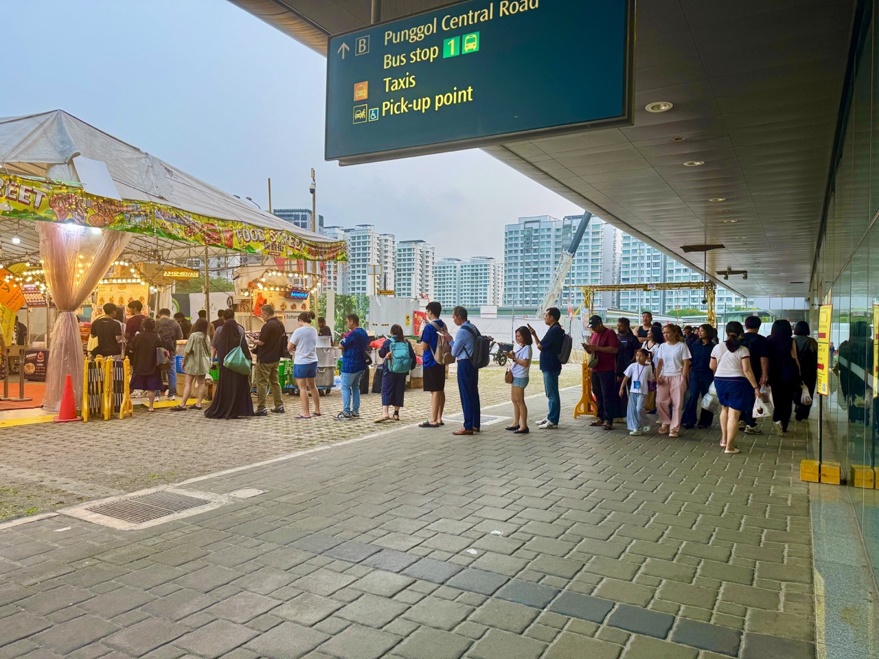 Shoppers queuing for nasi biryani at a night food market outside Punggol MRT station.